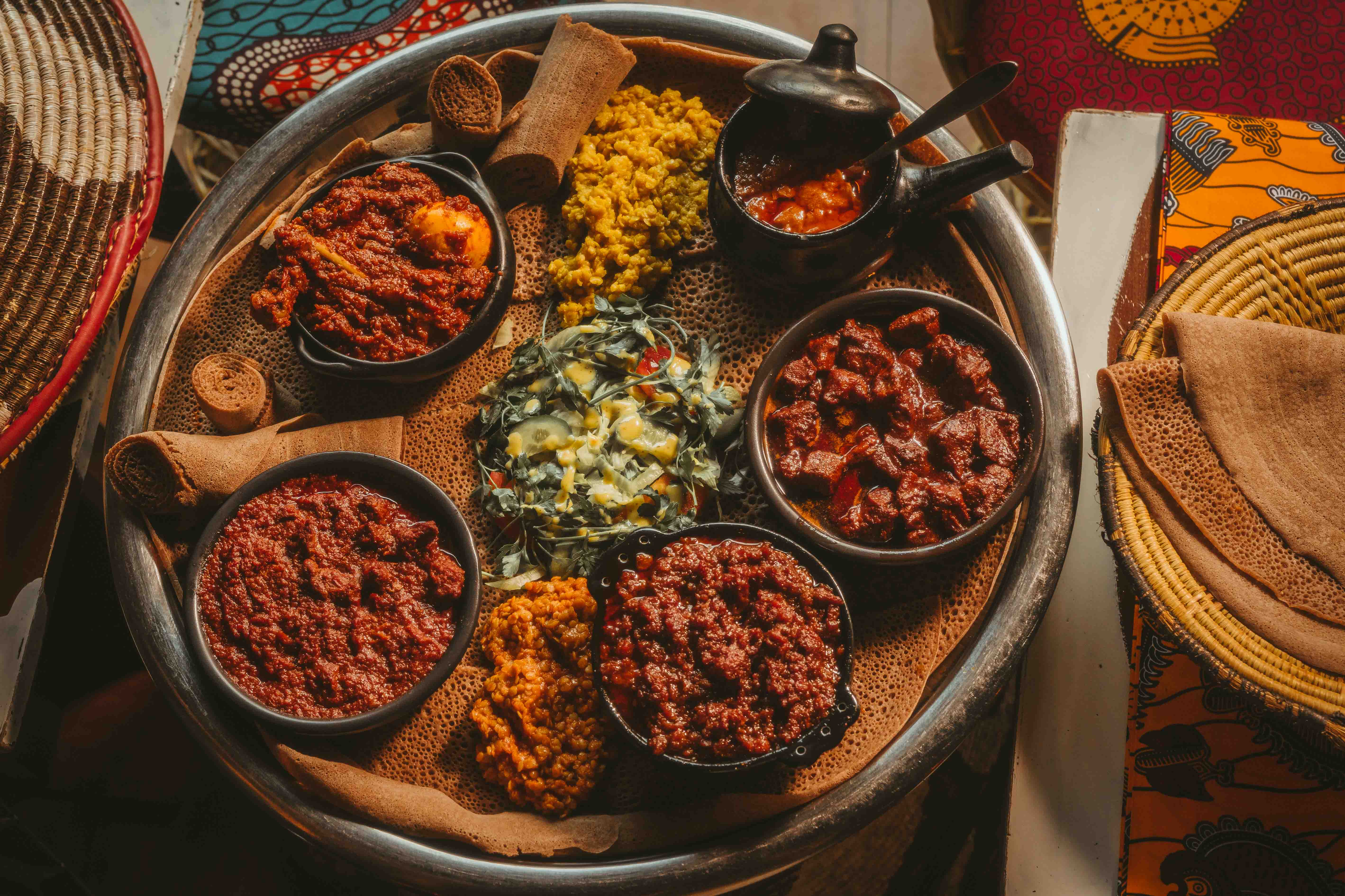 Traditional Ethiopian and Eritrean stews served together on teff injera